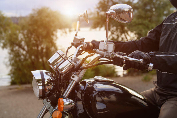 Person driving a motorcycle showing just the hands on the handle bar